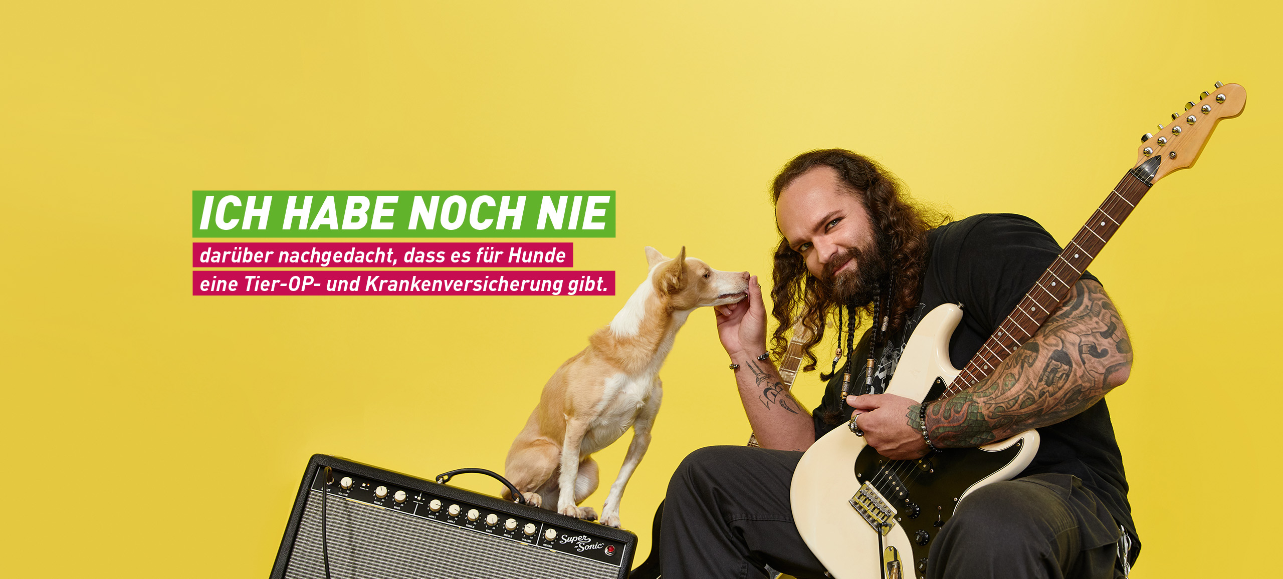 Ein rockiger Musiker ist mit seinem hellbraunen Hund beisammen. Im Hintergrund sieht man Verstärker und Gitarre.