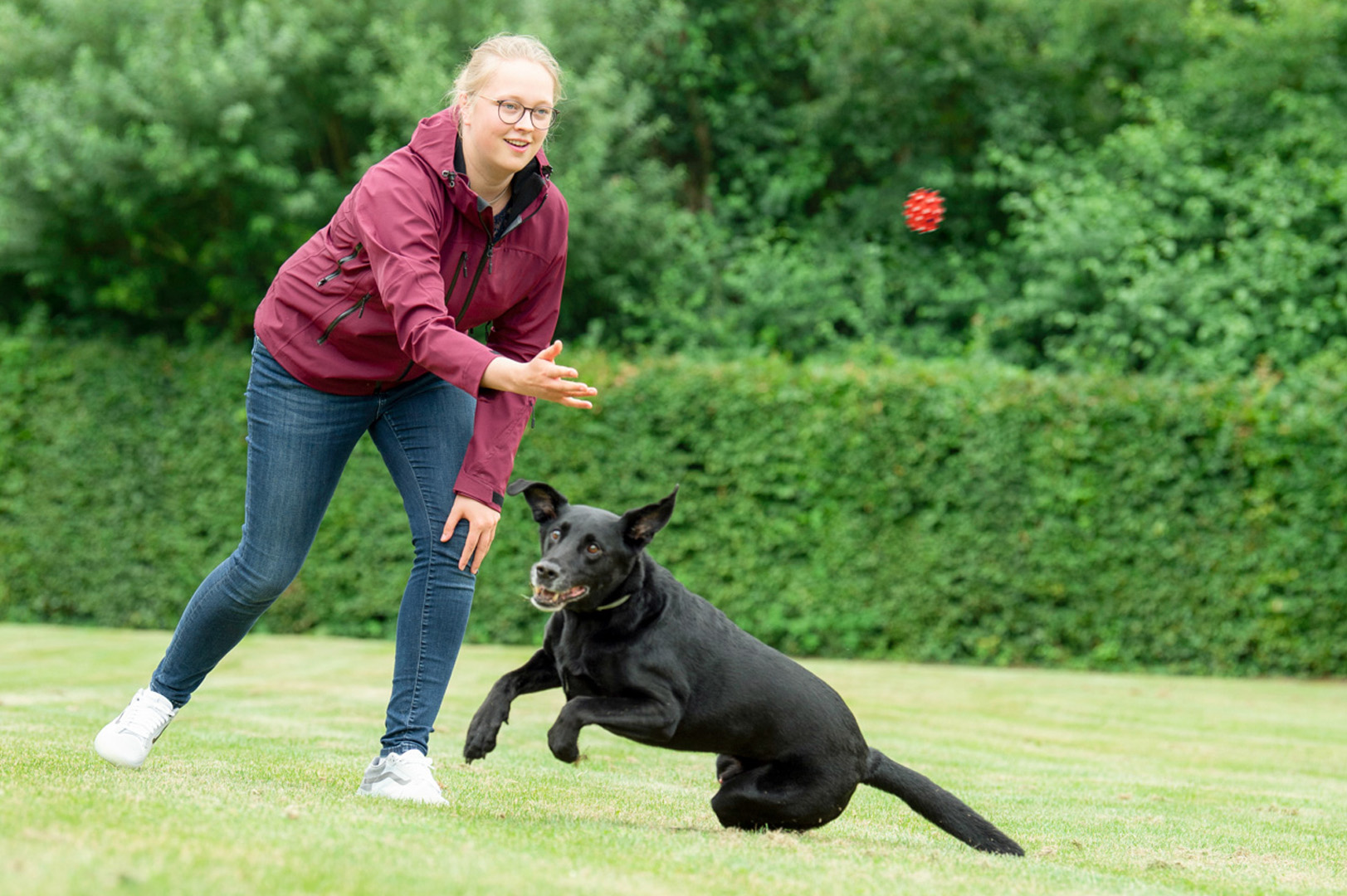 Jana wirft ihrem Mischlingshund Ajax einen Ball zu