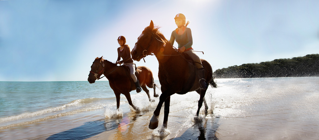 2 Frauen reiten mit Pferd am Stand