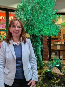 Imke Brammer-Rahlfs, Vorständin der Uelzener Versicherungen, mit Olivenbaum im Uelzener Hauptbahnhof.