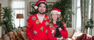 Katzenhalter und Katzenhalterin mit Katze auf dem Arm an Weihnachten.