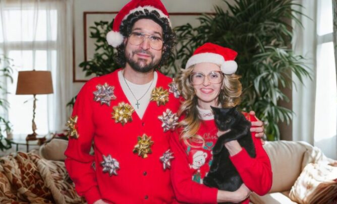 Katzenhalter und Katzenhalterin mit Katze auf dem Arm an Weihnachten.