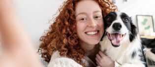 Glücklicher Hund mit Besitzerin bei einem Selfie.