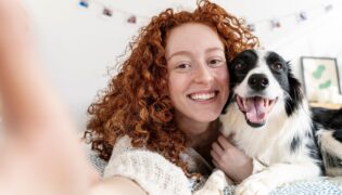 Glücklicher Hund mit Besitzerin bei einem Selfie.