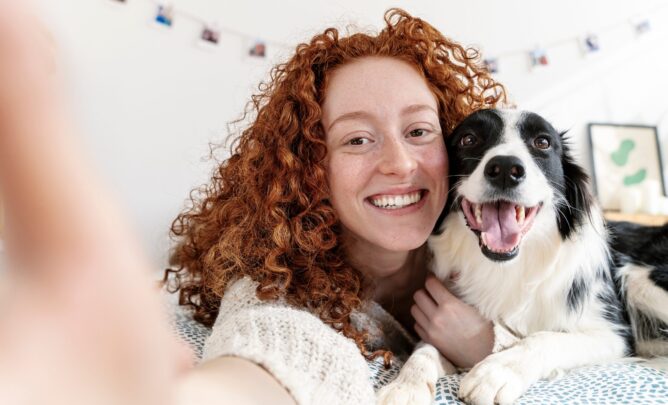 Glücklicher Hund mit Besitzerin bei einem Selfie.